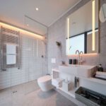 Modernes Badezimmer mit Regendusche, WC und großem Spiegel