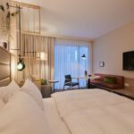 Komfortables Schlafzimmer mit Doppelbett, Sofa und Fernseher