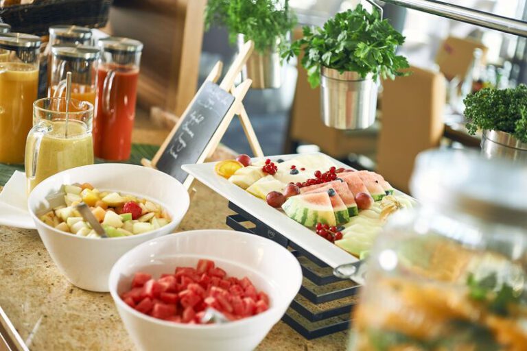 Auswahl an frisch geschnittenem Obst, Säften und Smoothies auf dem Frühstücksbuffet – ideal für einen vitalen Start in den Tag im Stadthotel
