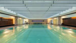 Großzügiger Hotelpool mit klarer Wasserfläche und heller Decke – Entspannung und Schwimmvergnügen im Spa-Bereich.