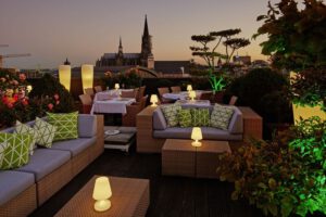 Abendliche Dachterrasse mit stilvollen Sitzmöbeln und Blick auf den Kölner Dom im Hintergrund